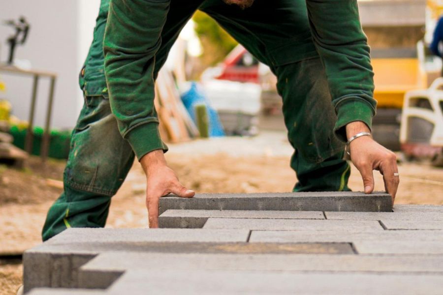 Installer setting pavers during new landscape construction